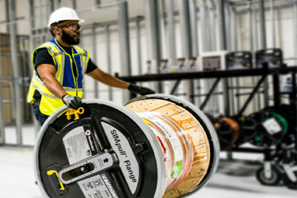 Worker pushing a spool of wire